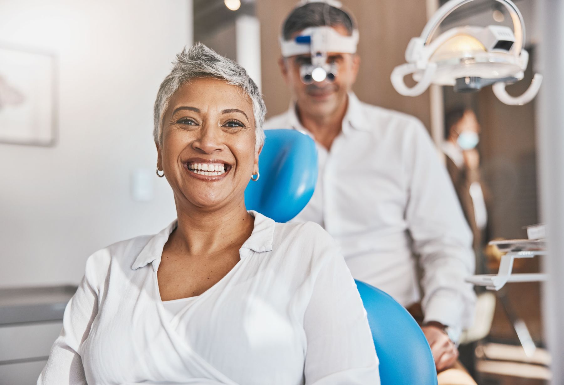 Smiling woman seated in a dental chair during an office visit
